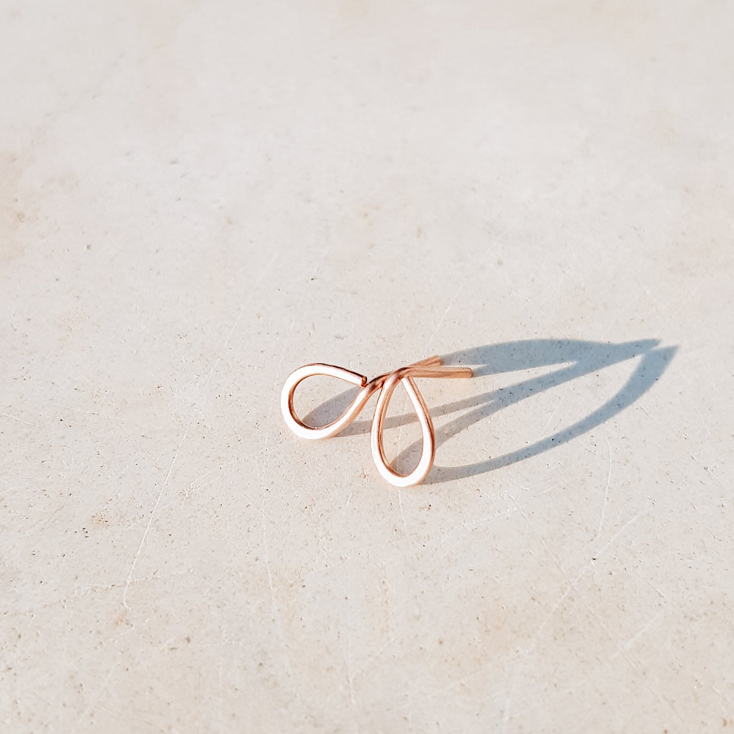 Minimal open drop stud earrings in gold filled sterling silver on neutral background with soft natural light