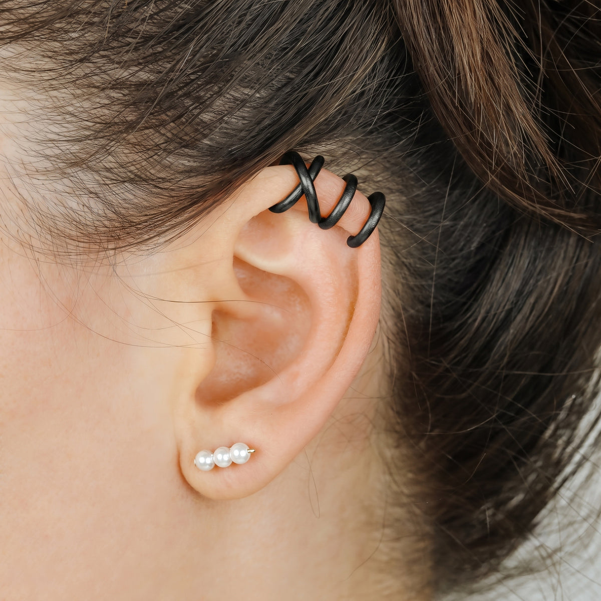 Adjustable no-piercing helix ear cuff shown worn on the upper cartilage area, available in silver, black and soft gold with Double Line and Criss-Cross style options for a bold stacked ear look.