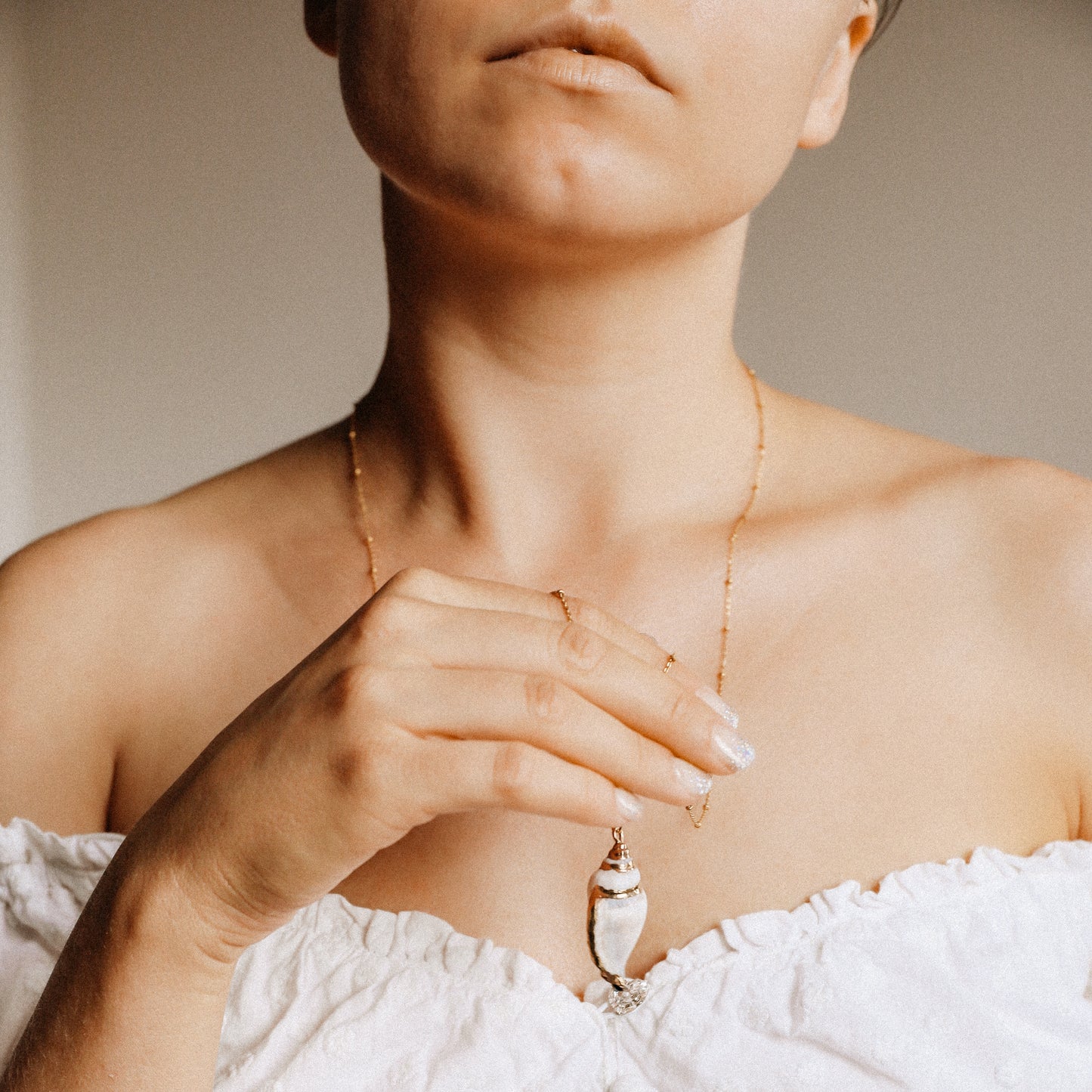 Delicate gold necklace with a real conch shell, perfect for adding ocean-inspired style to any outfit.