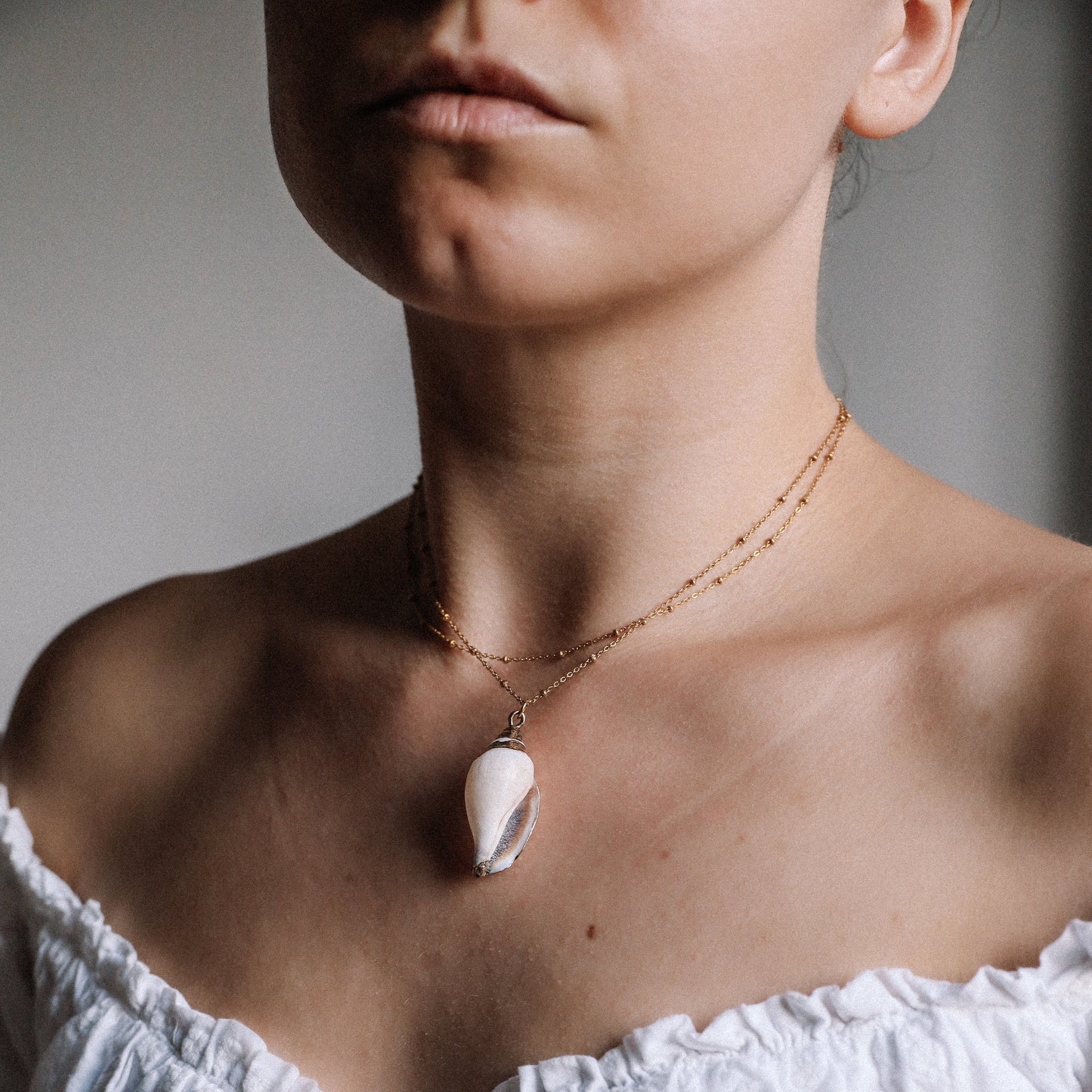Delicate gold necklace with a real conch shell, perfect for adding ocean-inspired style to any outfit.
