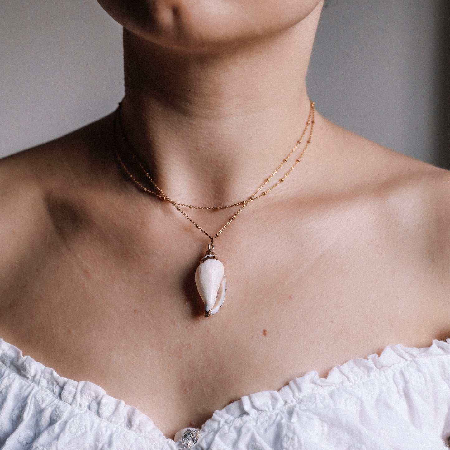 Delicate gold necklace with a real conch shell, perfect for adding ocean-inspired style to any outfit.