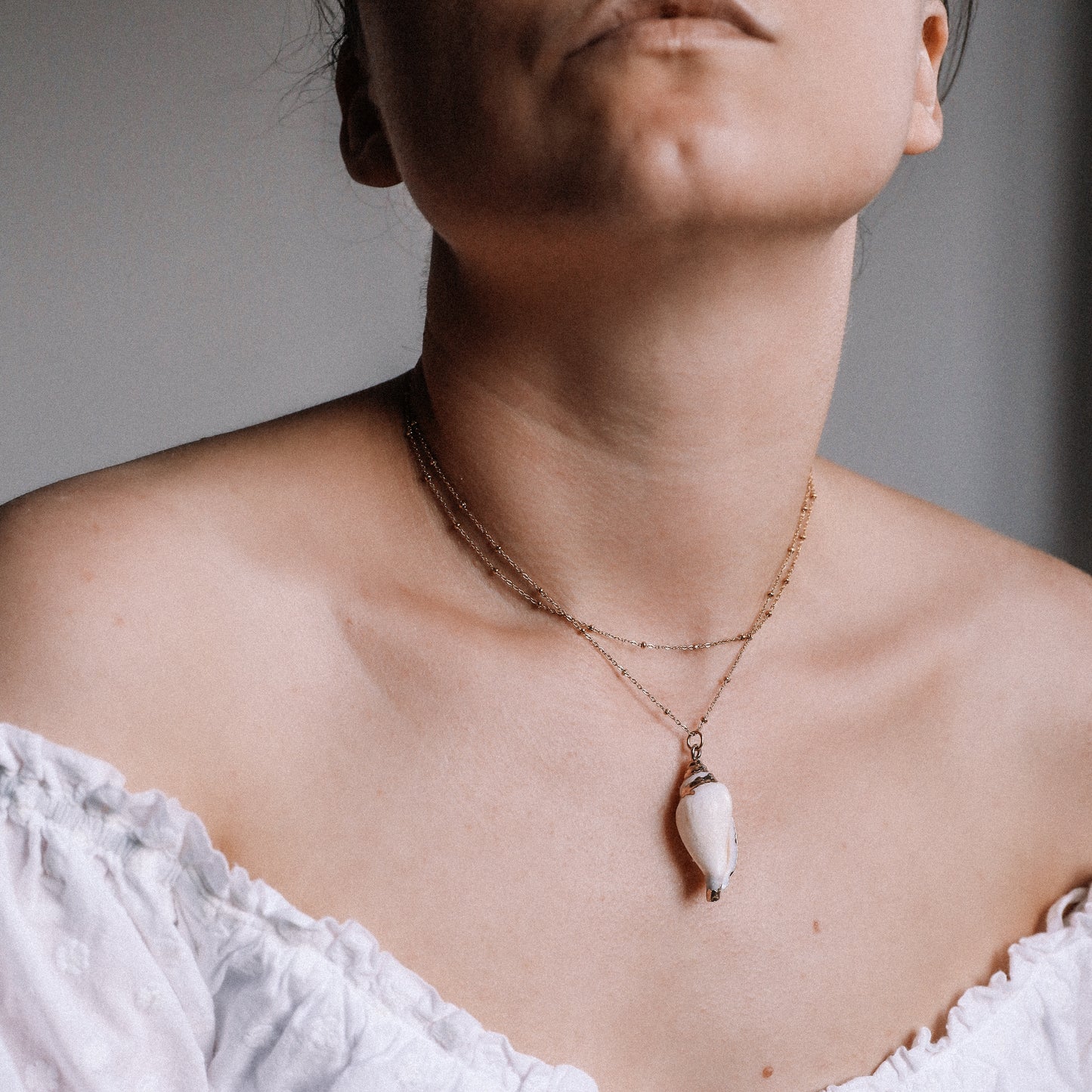 Delicate gold necklace with a real conch shell, perfect for adding ocean-inspired style to any outfit.