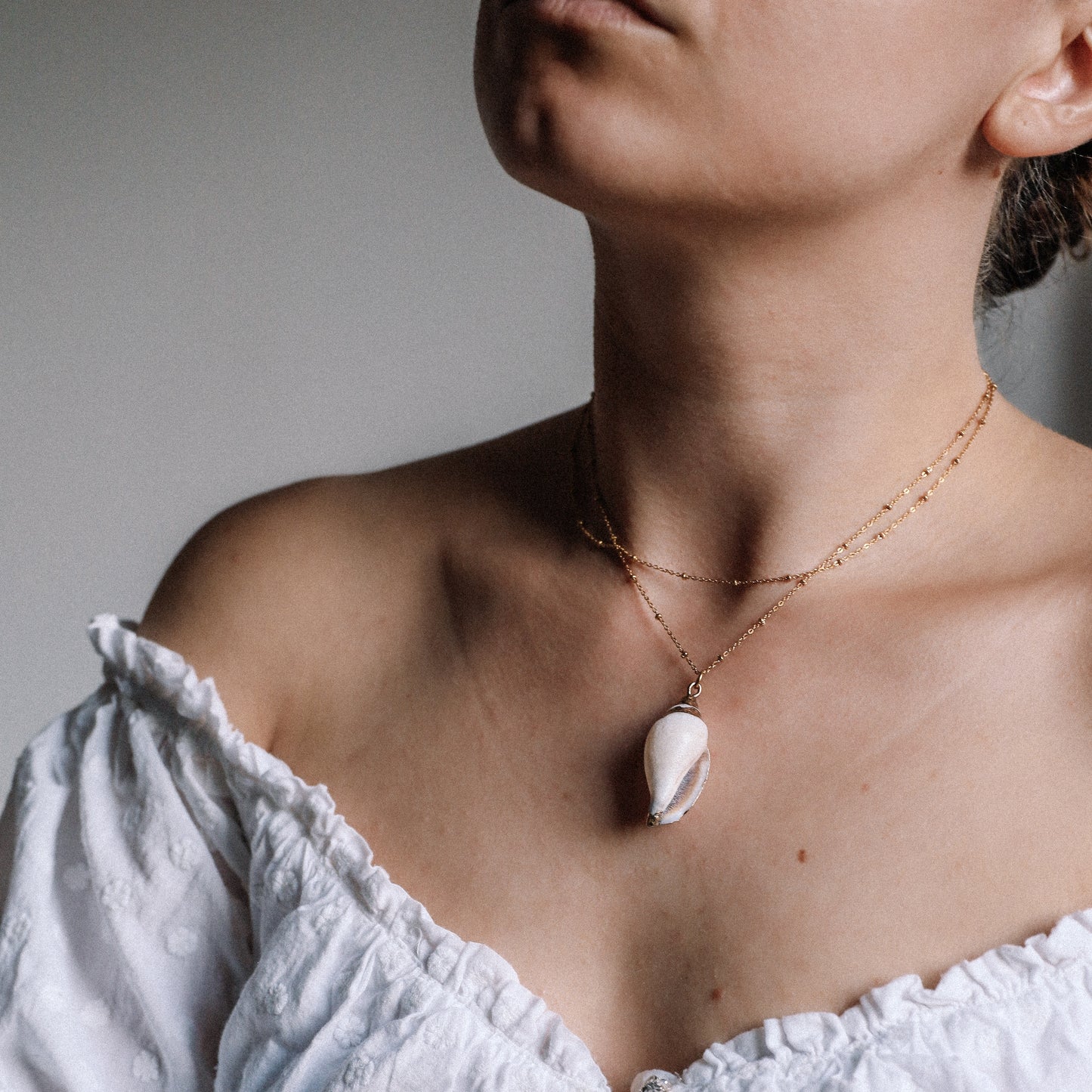 Delicate gold necklace with a real conch shell, perfect for adding ocean-inspired style to any outfit.