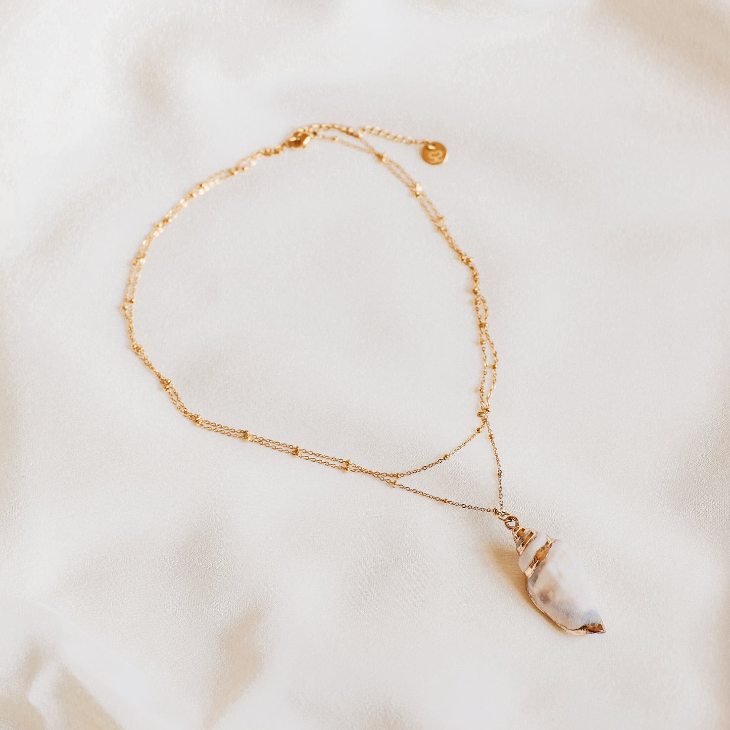 Delicate gold necklace with a real conch shell, perfect for adding ocean-inspired style to any outfit.