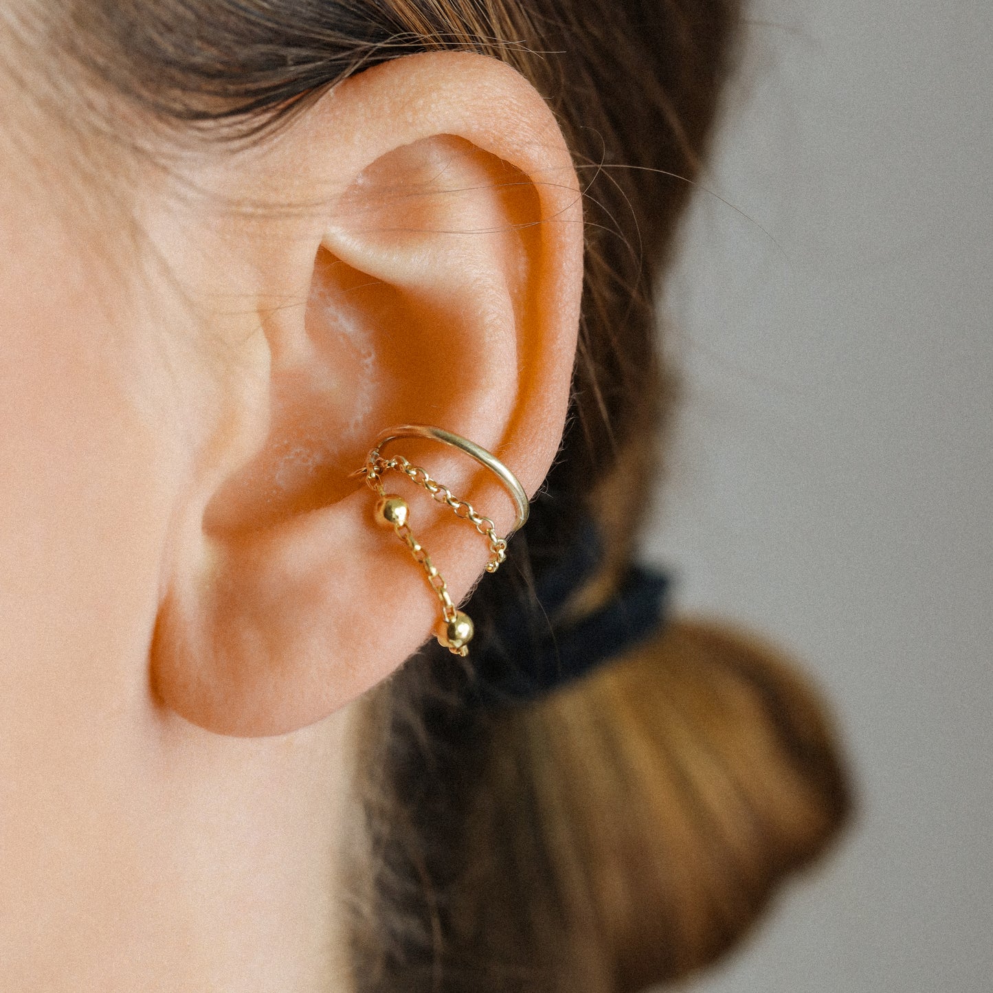 Gold beaded chain ear cuff worn on the conch with double draped chain detail