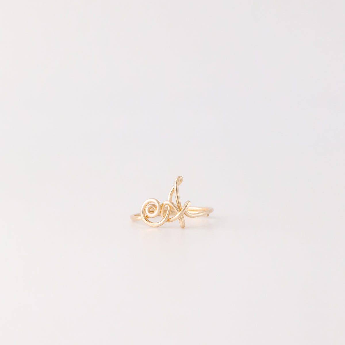 Dainty handmade gold wire ring with an uppercase cursive letter A.