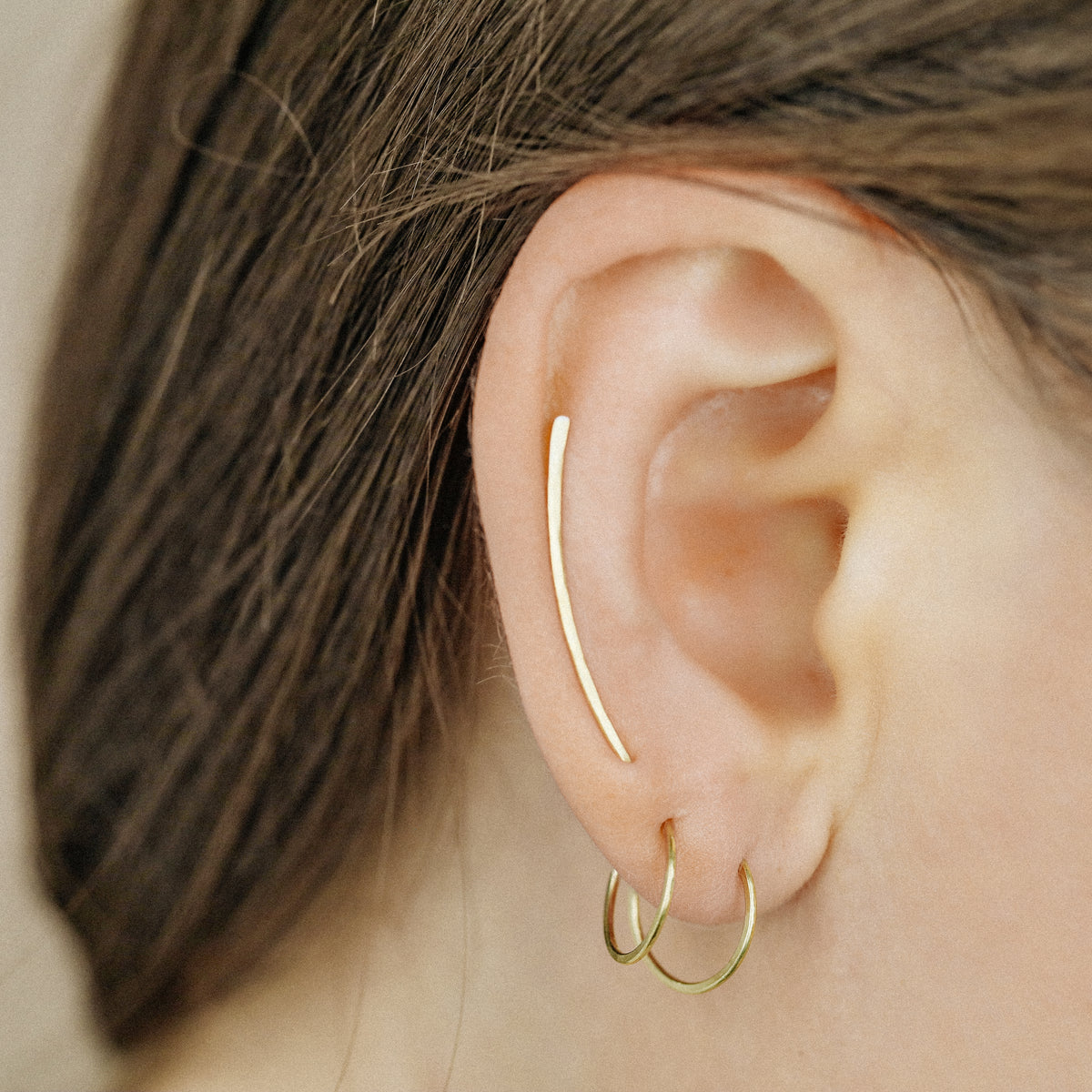 Close-up detail of thin round wire hoop earrings with minimal open design