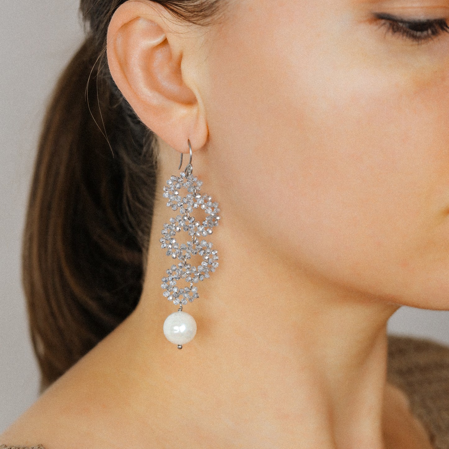Elegant silver iridescent serpentine earrings worn with long cascading dangle design