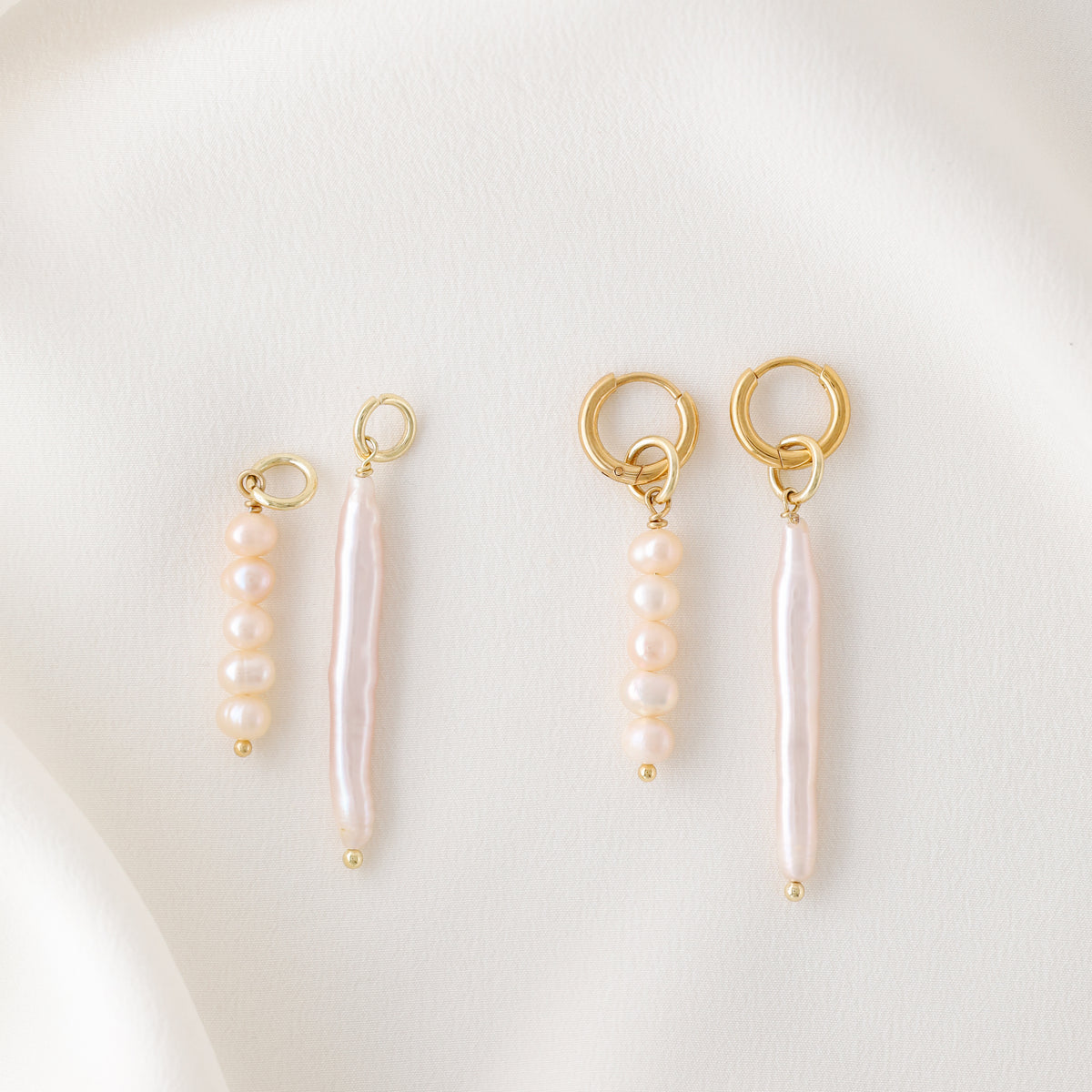 An overhead view showing the individual components of the earrings: two gold hoops, two pink pearl cluster charms, and two long linear stick pearls.