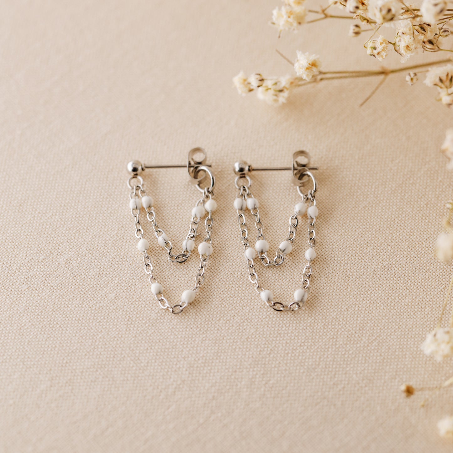 Silver chain dangle earrings with tiny white enamel beads and stud post closure