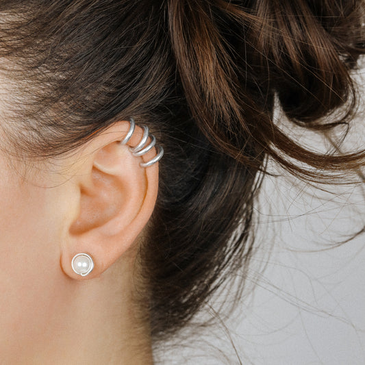Adjustable no-piercing helix ear cuff shown worn on the upper cartilage area, available in silver, black and soft gold with Double Line and Criss-Cross style options for a bold stacked ear look.