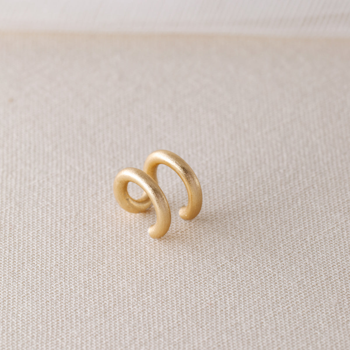Adjustable no-piercing helix ear cuff shown worn on the upper cartilage area, available in silver, black and soft gold with Double Line and Criss-Cross style options for a bold stacked ear look.