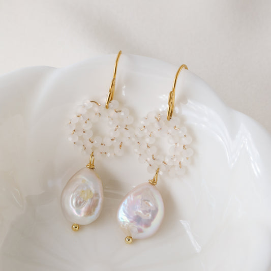 Stainless steel baroque pearl and white crystal wreath drop earrings presented inside a minimalist white ceramic flower-shaped bowl.