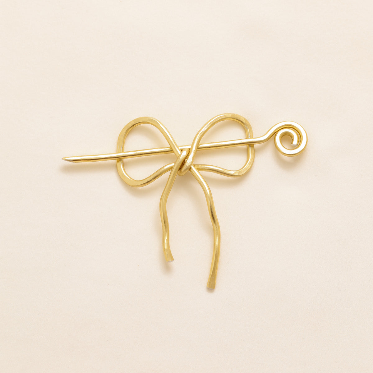 Handmade aluminum bow shawl pin brooch with matching removable stick pin, shown in gold and available in silver or gold finish, designed as a decorative and functional scarf fastener for shawls, sweaters, cardigans, knit wraps and crochet pieces, with a romantic bow shape and minimalist metal design.