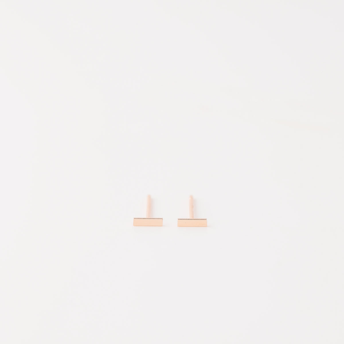 Tiny rectangle bar stud earrings in solid 925 sterling silver on white background