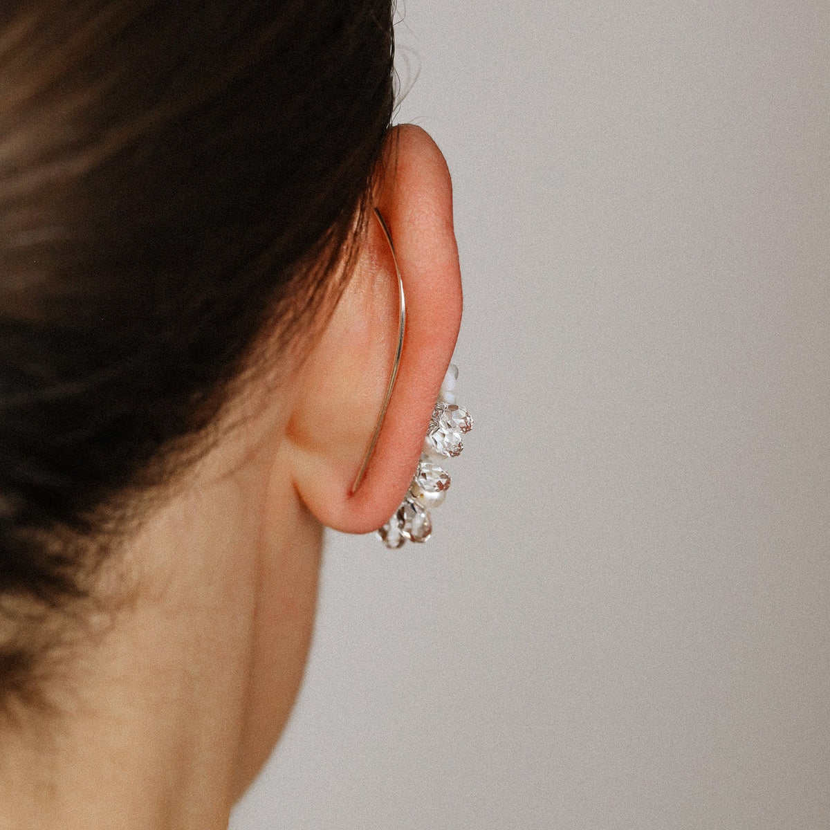 Side view of bridal floral ear climbers styled with pearls and sparkling crystal drops