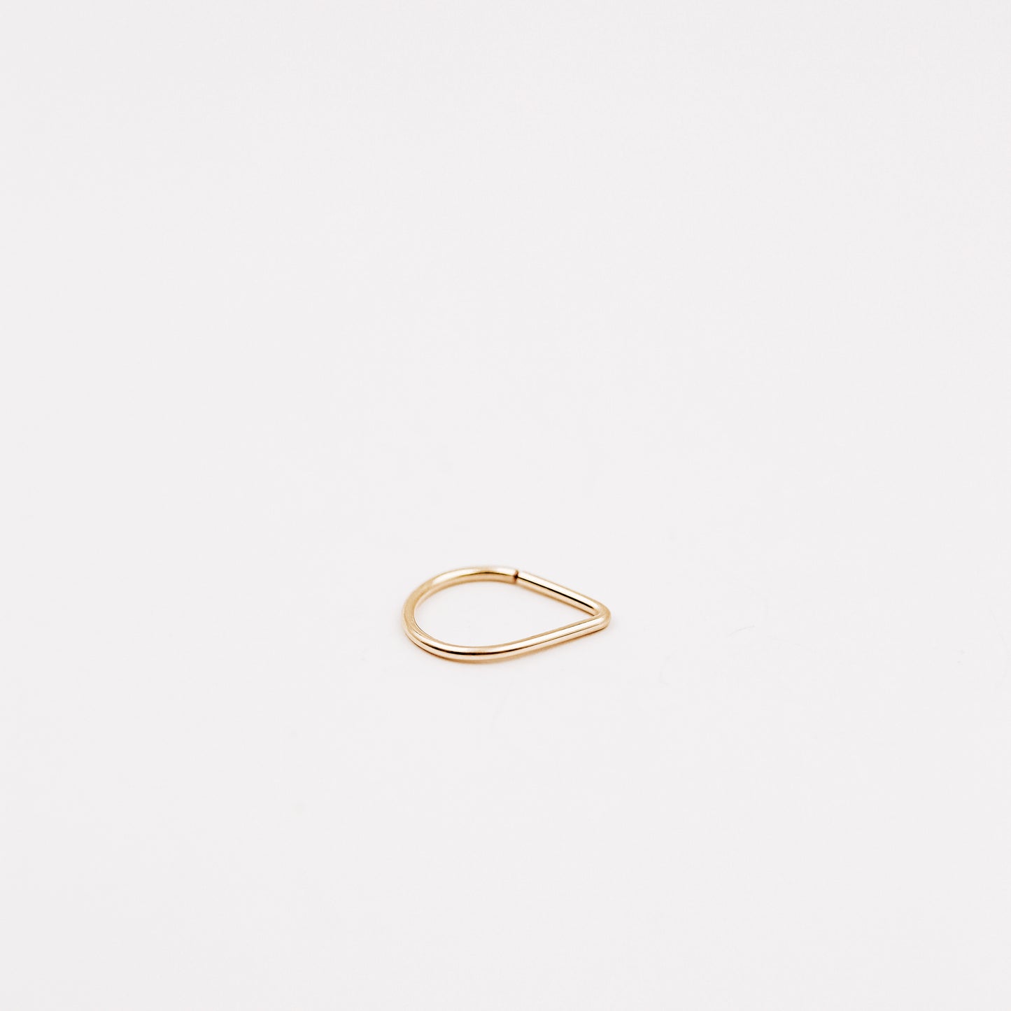 Gold filled chevron septum ring with open hoop design on a clean white background.