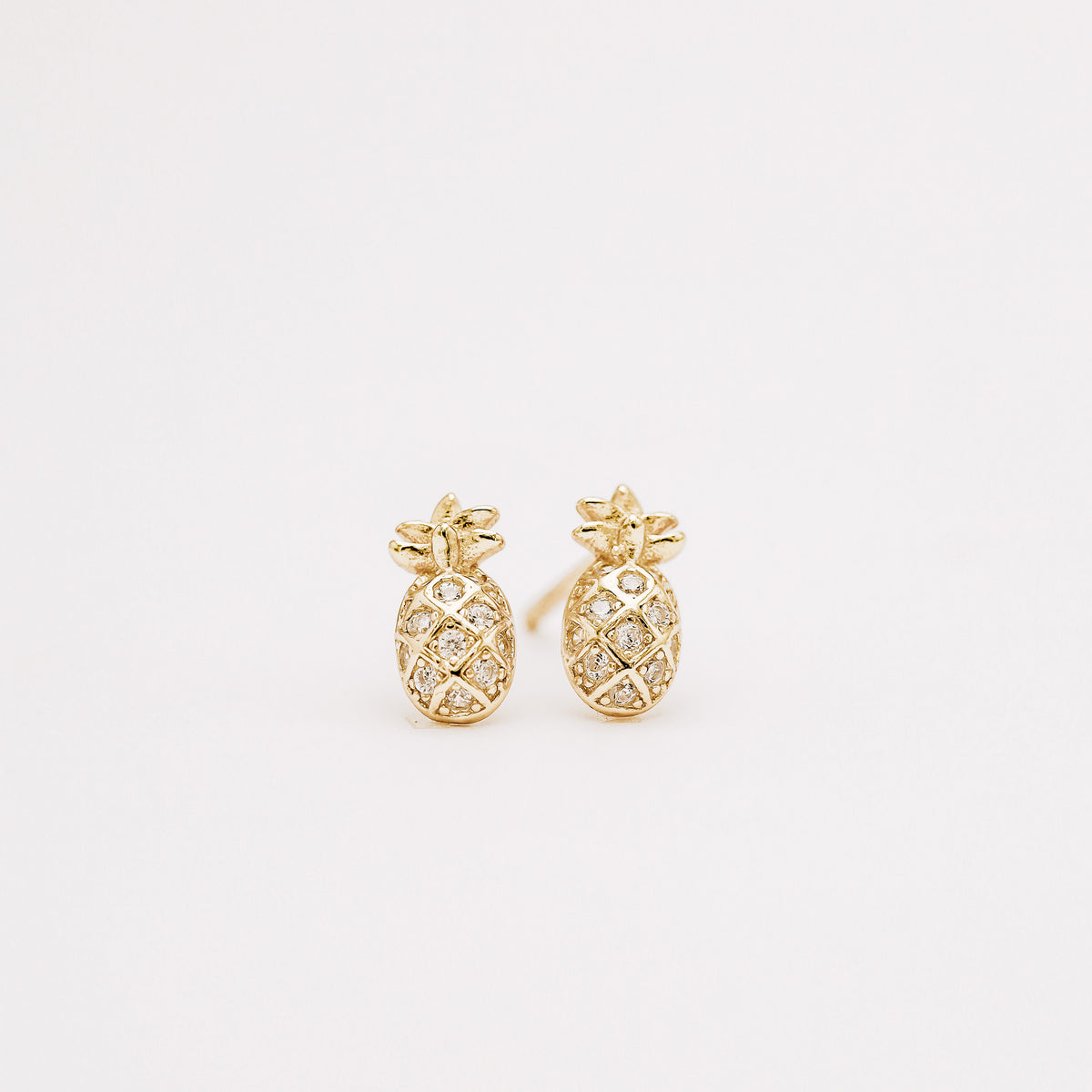 Small pineapple stud earrings with cubic zirconia on white background