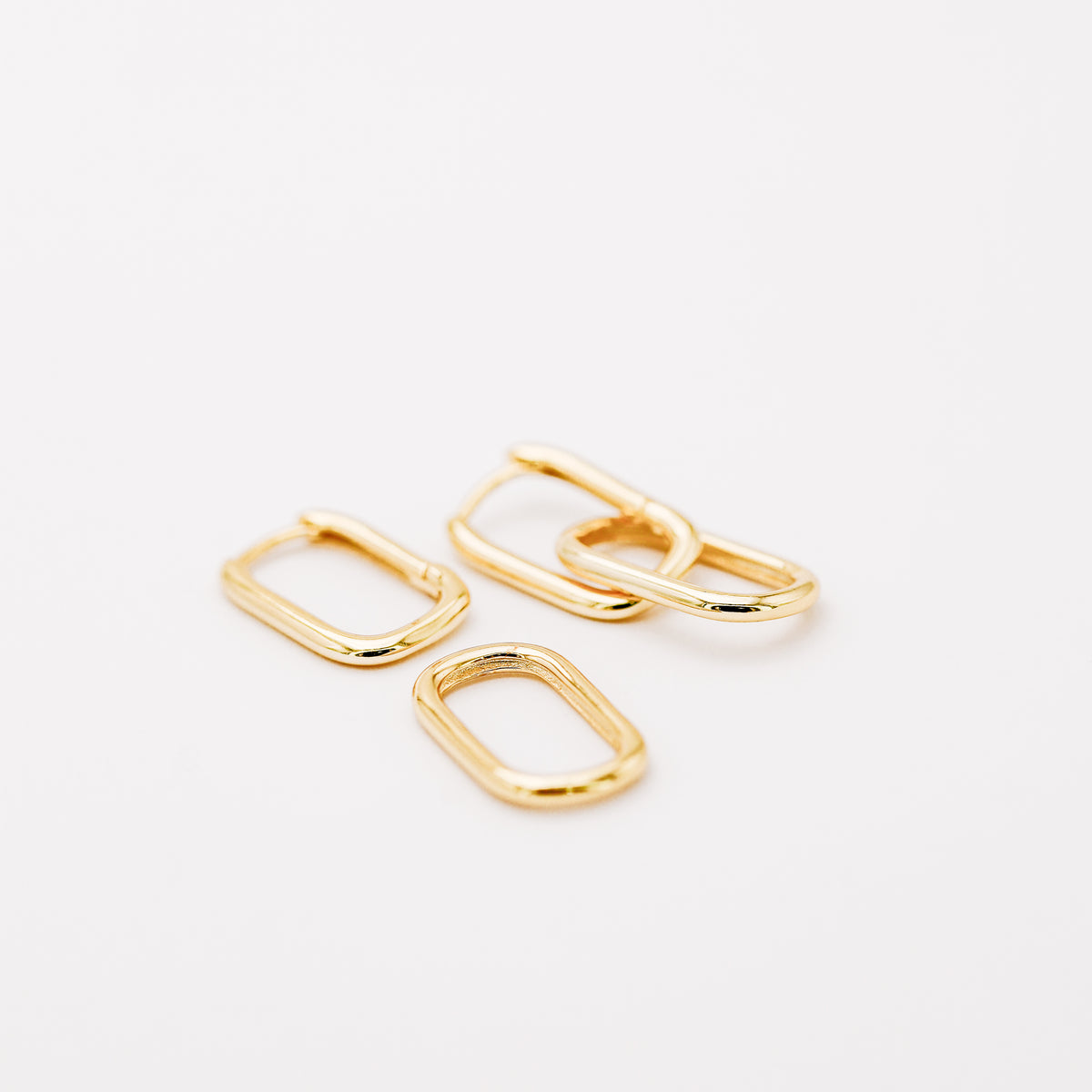 Gold hinged hoop earrings showing the polished double link construction