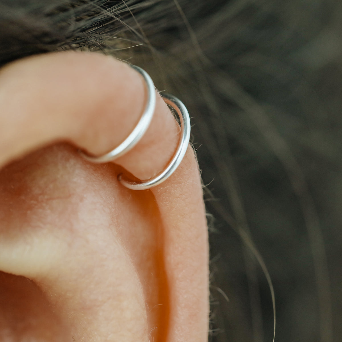No-piercing double line and criss cross helix ear cuff shown on the upper ear, with smooth and diamond cut finish options for cartilage styling.