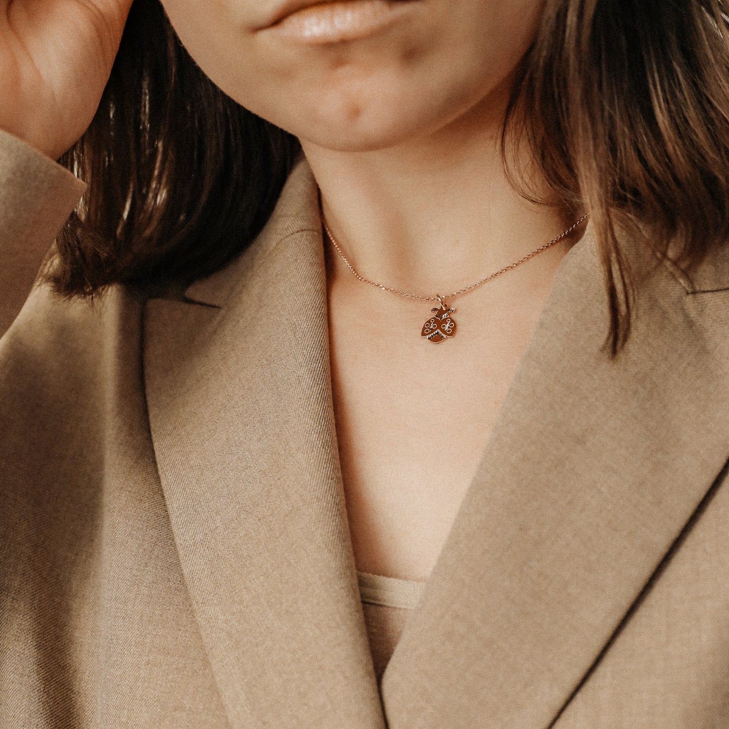 Ladybug necklace worn by model with beige blazer for elegant everyday styling