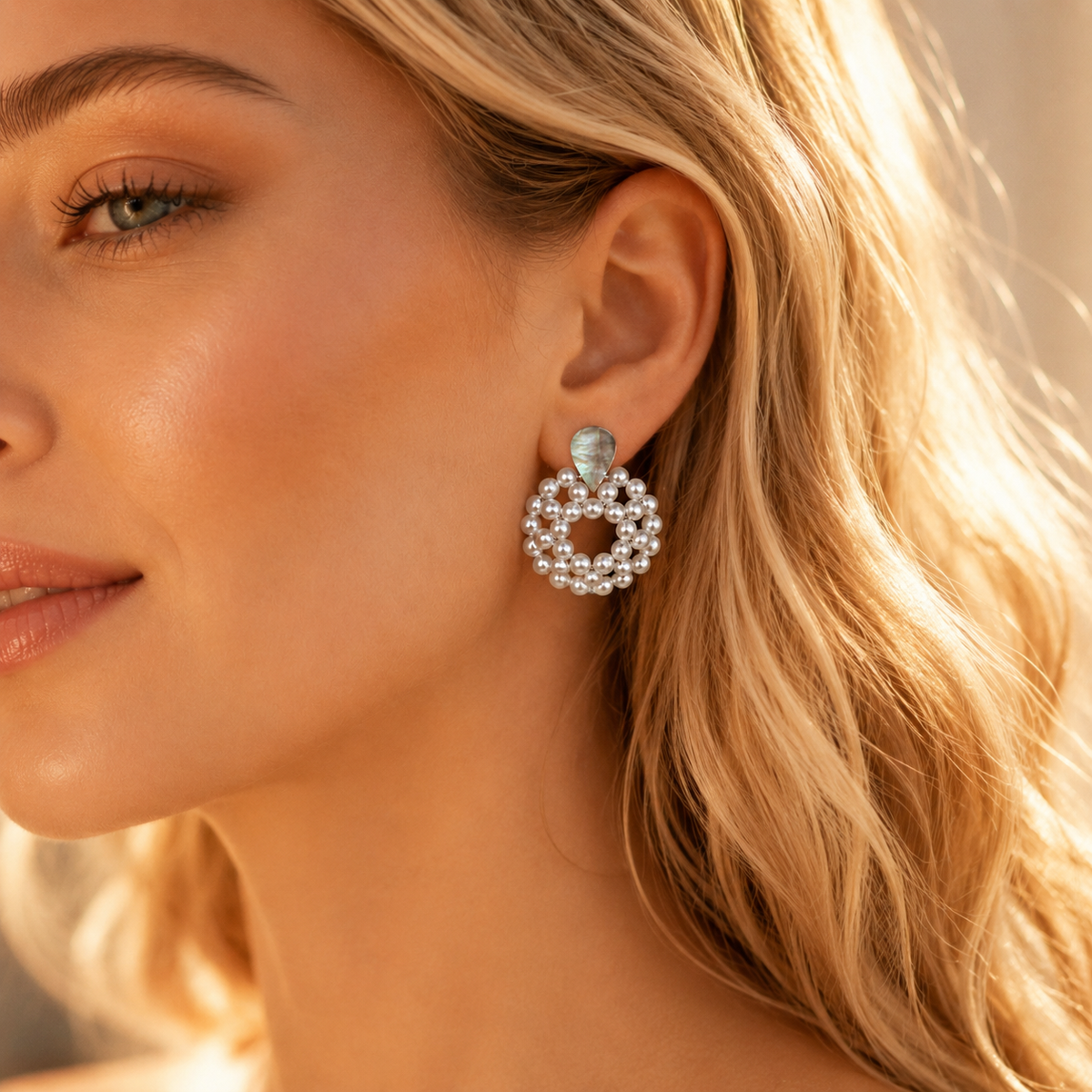 Close up of pearl hoop dangle earrings with teardrop mother of pearl abalone detail