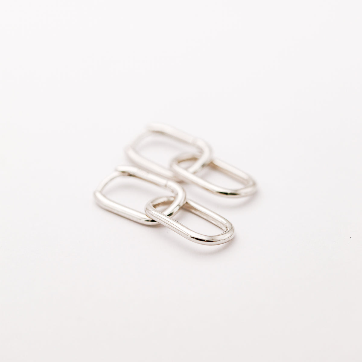 Pair of silver double open-link hoop earrings displayed on white background