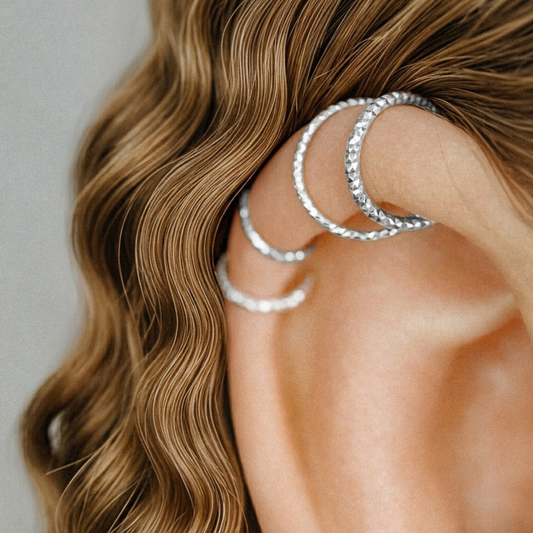 Close-up of three 925 Sterling Silver diamond-cut endless hoop earrings in a helix piercing.