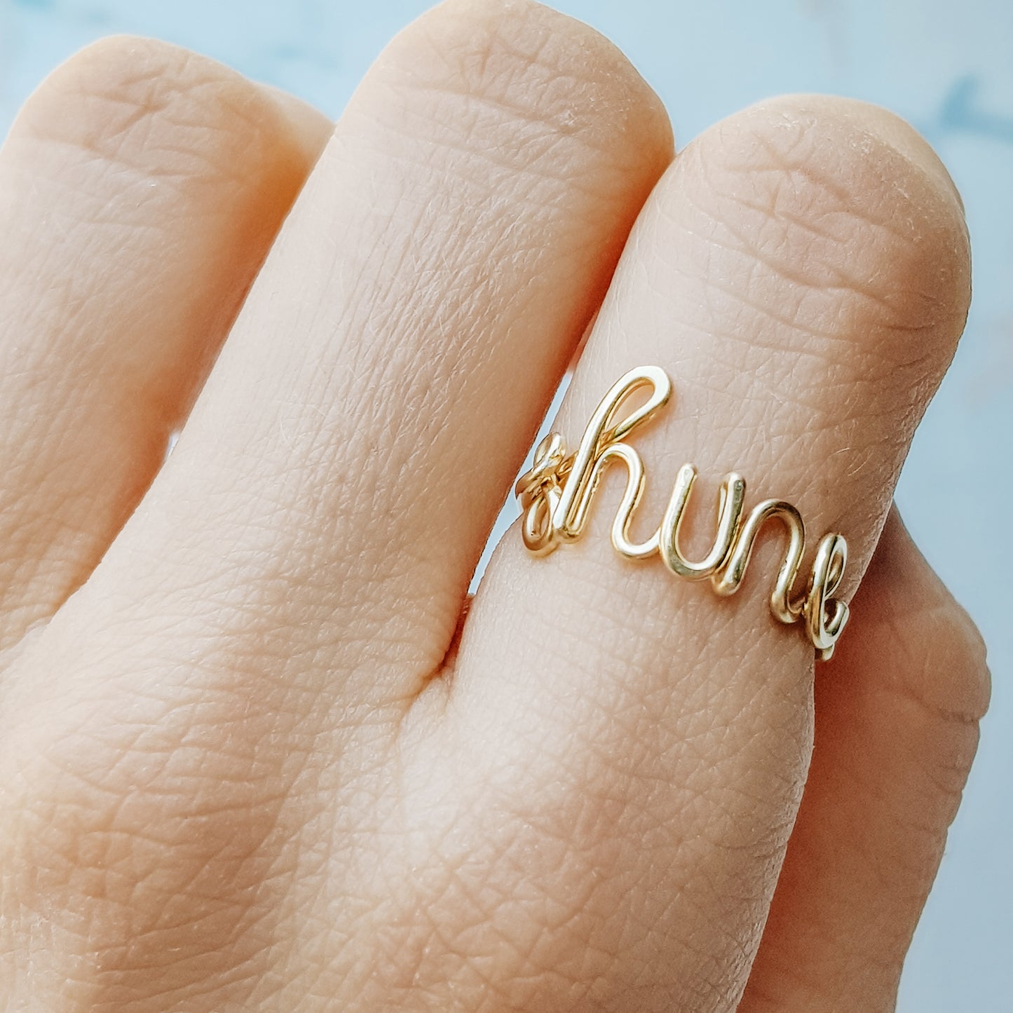 Dainty gold wire ring featuring the custom name "shine" in lowercase cursive.