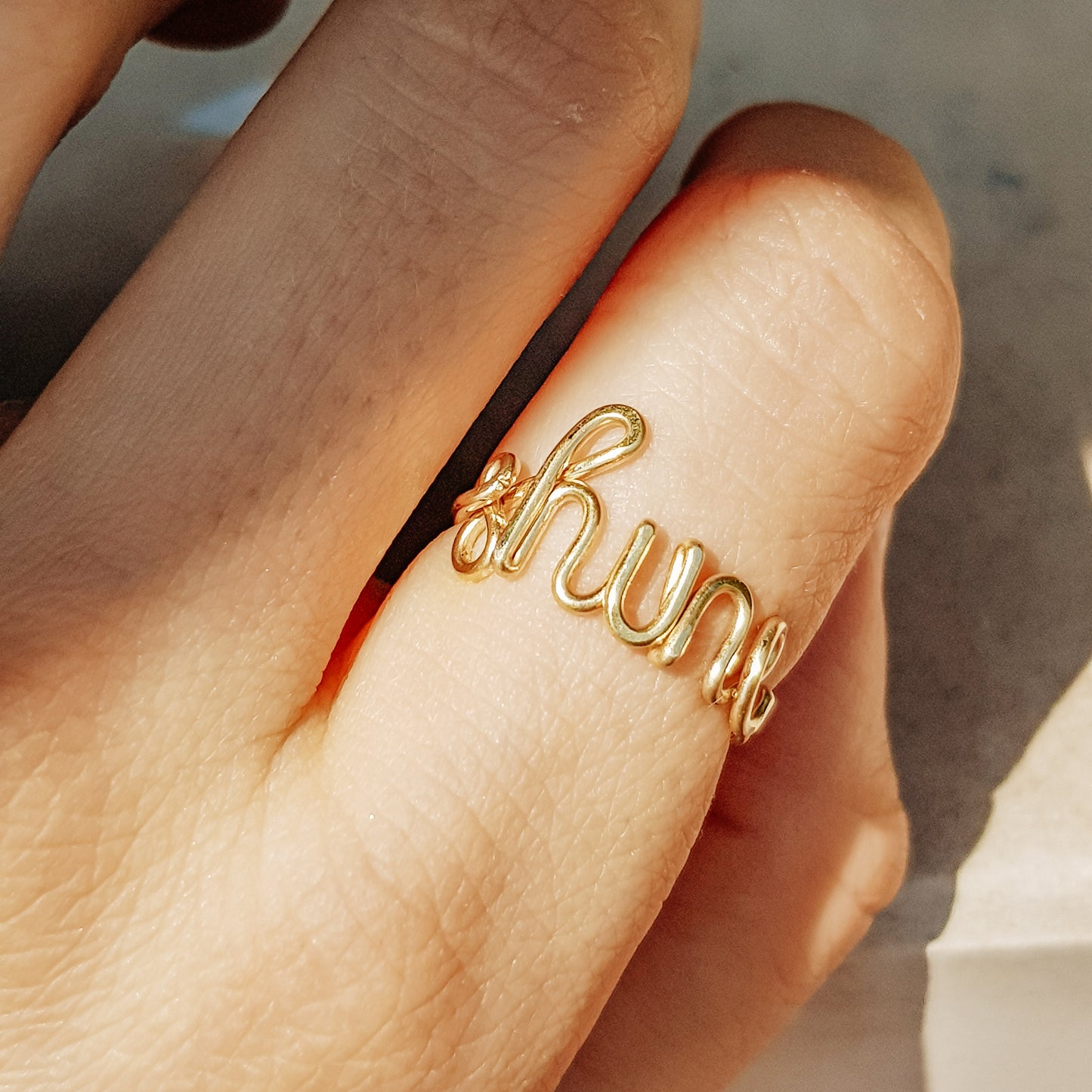 Dainty gold wire ring featuring the custom name "shine" in lowercase cursive.