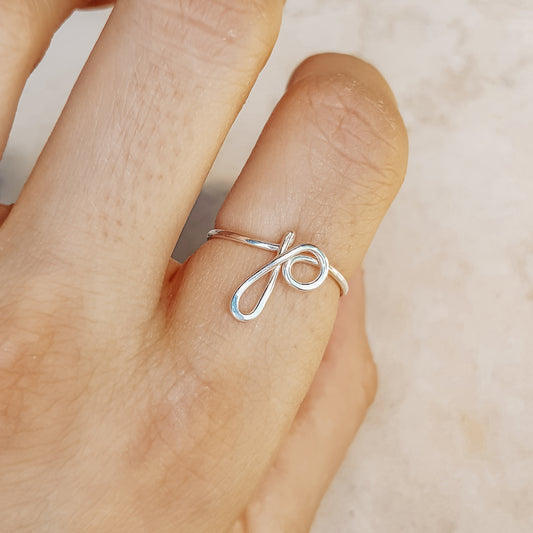 Handmade dainty wire ring featuring a lowercase cursive letter P in gold, worn on a hand.