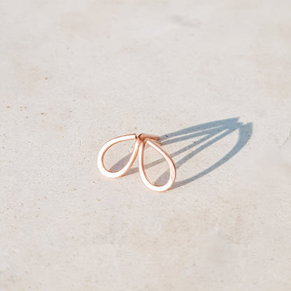 Minimal open drop stud earrings in gold filled sterling silver on neutral background with soft natural light