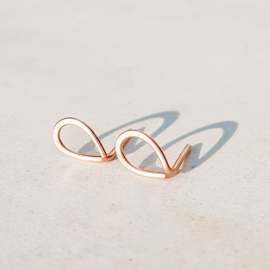 Minimal open drop stud earrings in gold filled sterling silver on neutral background with soft natural light