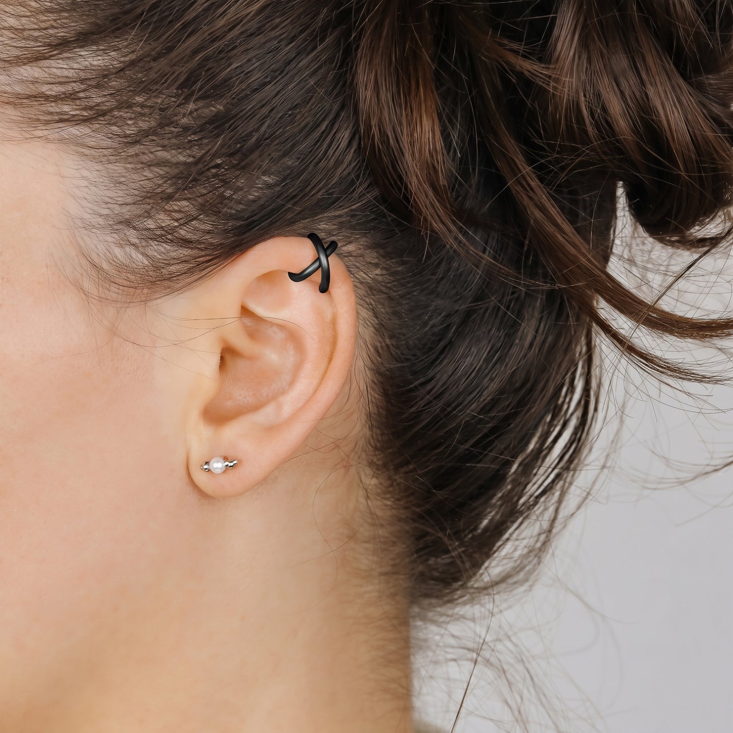 Adjustable no-piercing helix ear cuff shown worn on the upper cartilage area, available in soft gold, silver and black with Double Line and Criss-Cross style options for a bold stacked ear look.
