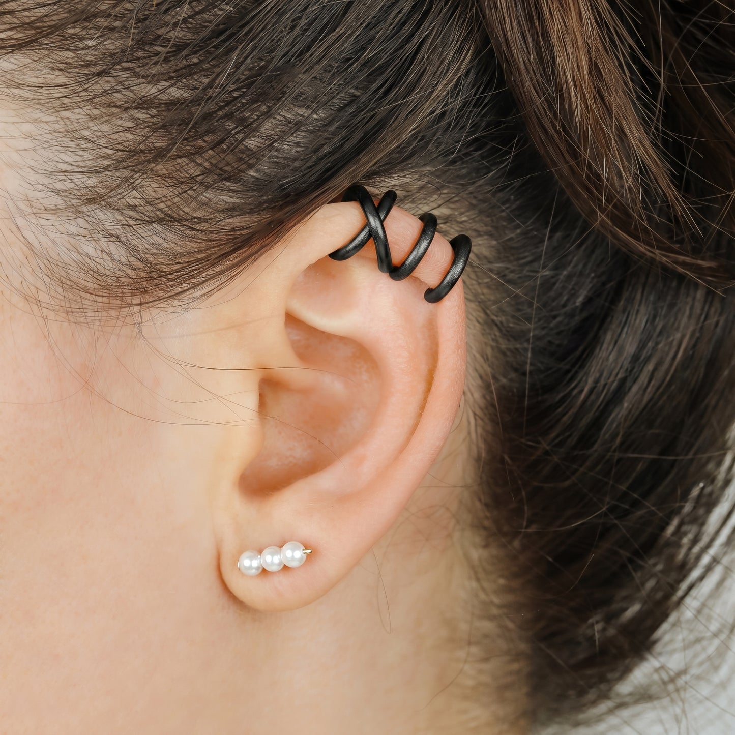 Adjustable no-piercing helix ear cuff shown worn on the upper cartilage area, available in silver, black and soft gold with Double Line and Criss-Cross style options for a bold stacked ear look.