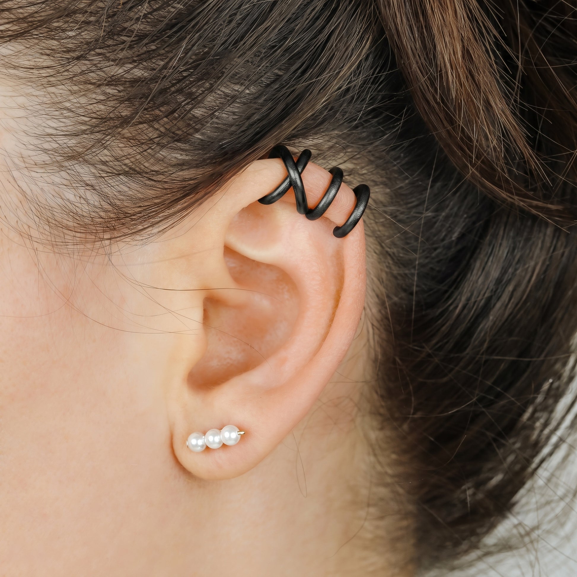 Adjustable no-piercing helix ear cuff shown worn on the upper cartilage area, available in silver, black and soft gold with Double Line and Criss-Cross style options for a bold stacked ear look.
