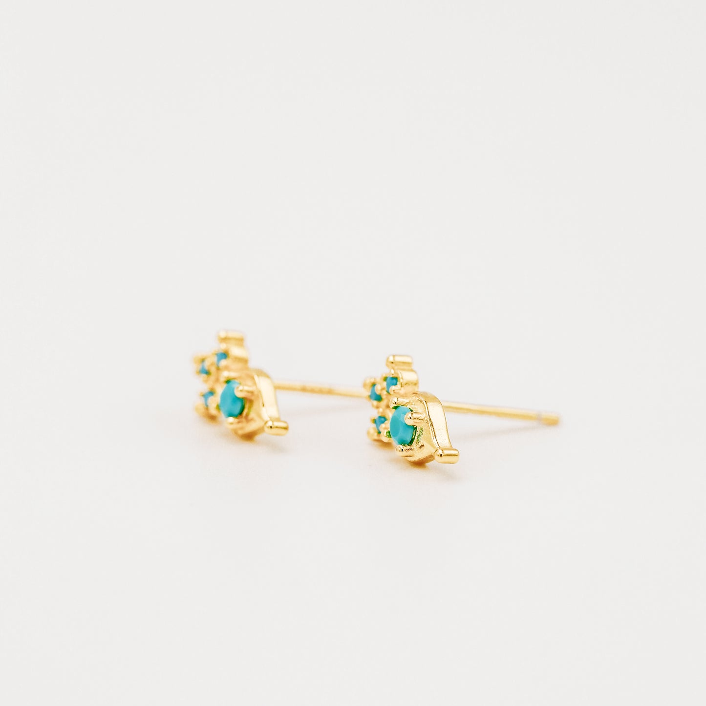 Gold turquoise earrings shown from side profile on white background