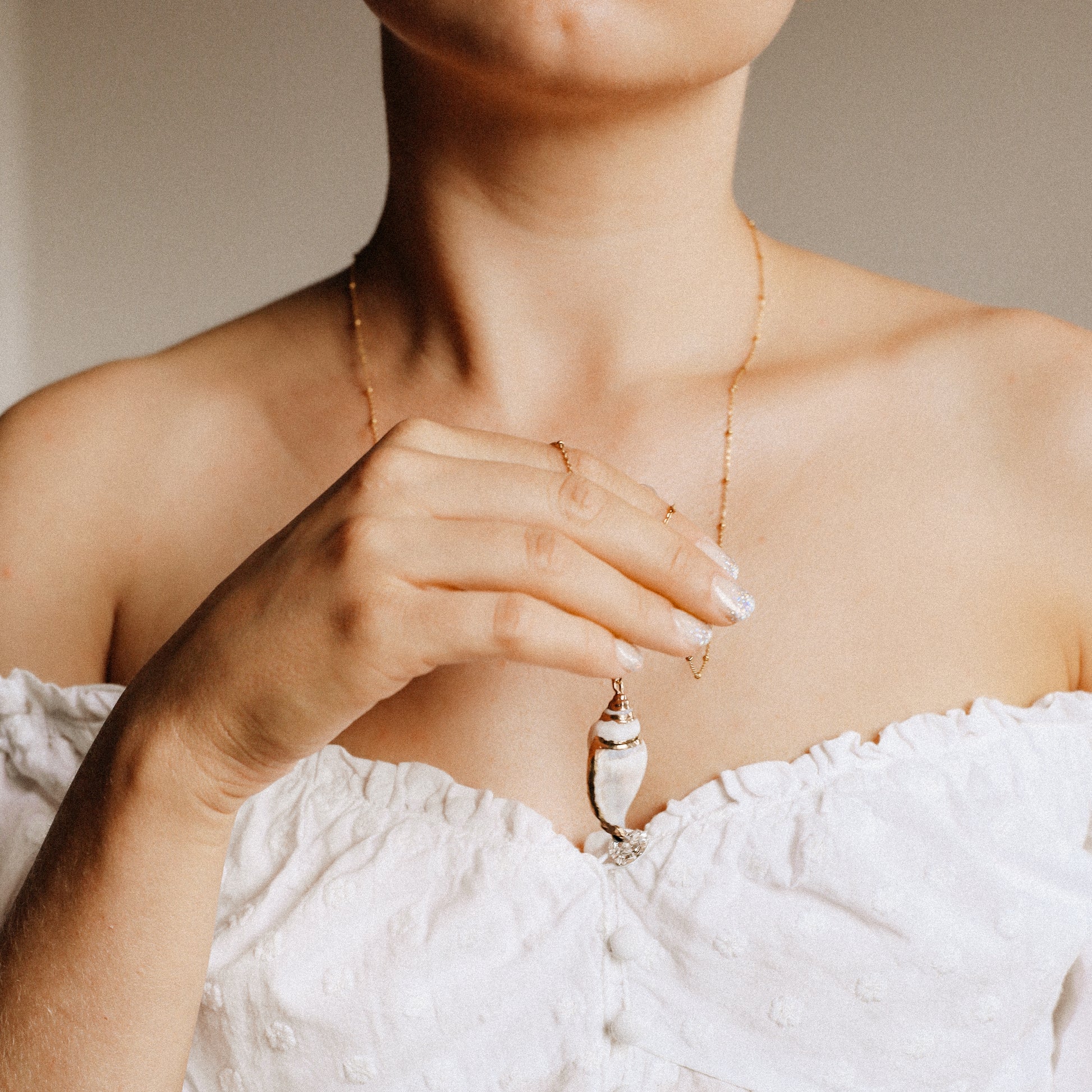 Delicate gold necklace with a real conch shell, perfect for adding ocean-inspired style to any outfit.