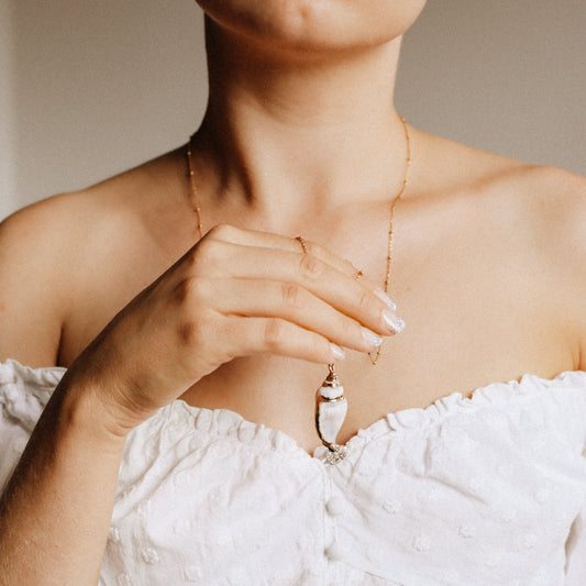 Delicate gold necklace with a real conch shell, perfect for adding ocean-inspired style to any outfit.