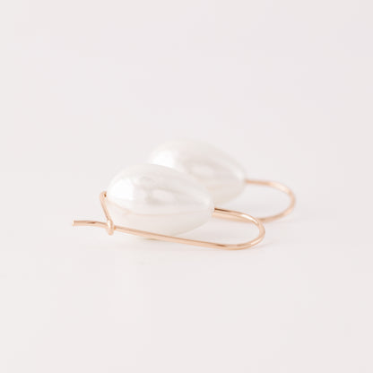 Handmade ceramic pearl teardrop earrings featuring large white pear-shaped pearls approximately 20 mm x 15 mm suspended from a minimalist curved wire hook, approximately 30 mm total length, available in solid 925 sterling silver, 14k gold filled or 14k rose gold filled.