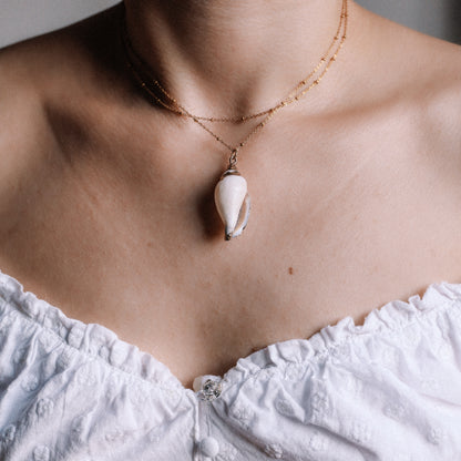 Delicate gold necklace with a real conch shell, perfect for adding ocean-inspired style to any outfit.