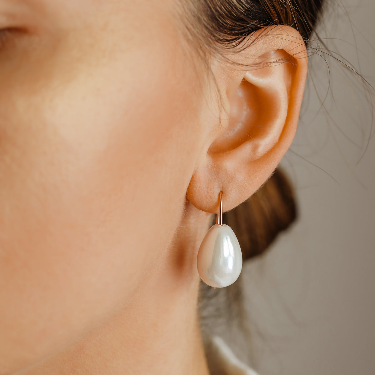 Handmade ceramic pearl teardrop earrings featuring large white pear-shaped pearls approximately 20 mm x 15 mm suspended from a minimalist curved wire hook, approximately 30 mm total length, available in solid 925 sterling silver, 14k gold filled or 14k rose gold filled.