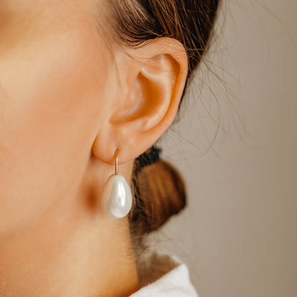 Handmade ceramic pearl teardrop earrings featuring large white pear-shaped pearls approximately 20 mm x 15 mm suspended from a minimalist curved wire hook, approximately 30 mm total length, available in solid 925 sterling silver, 14k gold filled or 14k rose gold filled.