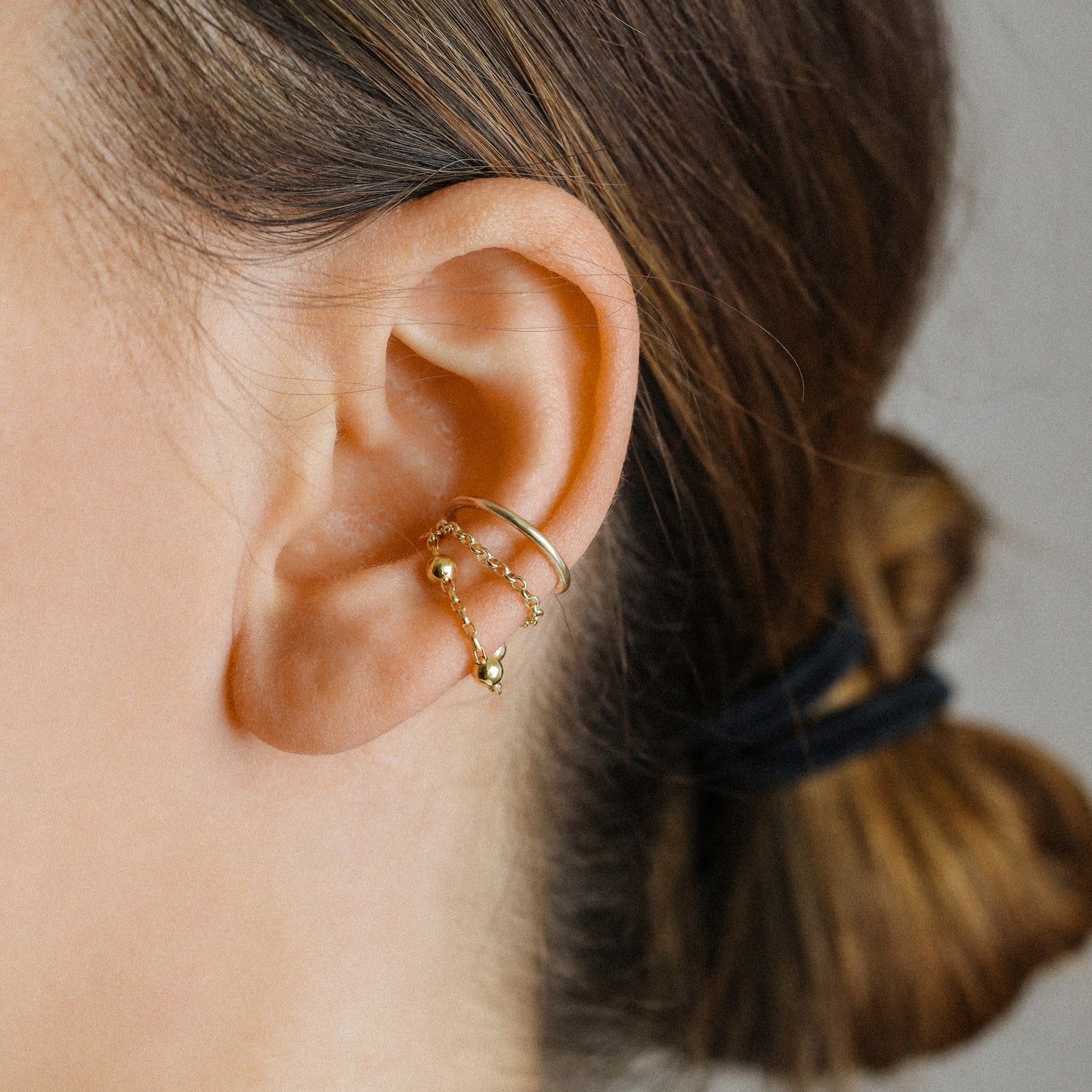 Gold beaded chain ear cuff worn on the conch with double draped chain detail