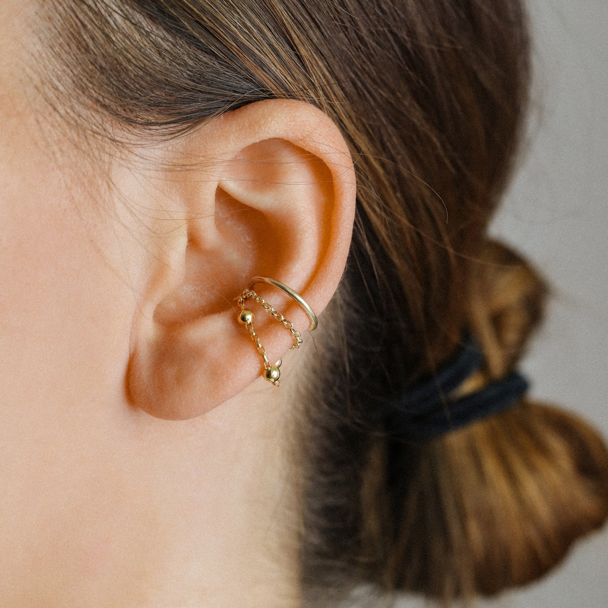 Gold beaded chain ear cuff worn on the conch with double draped chain detail