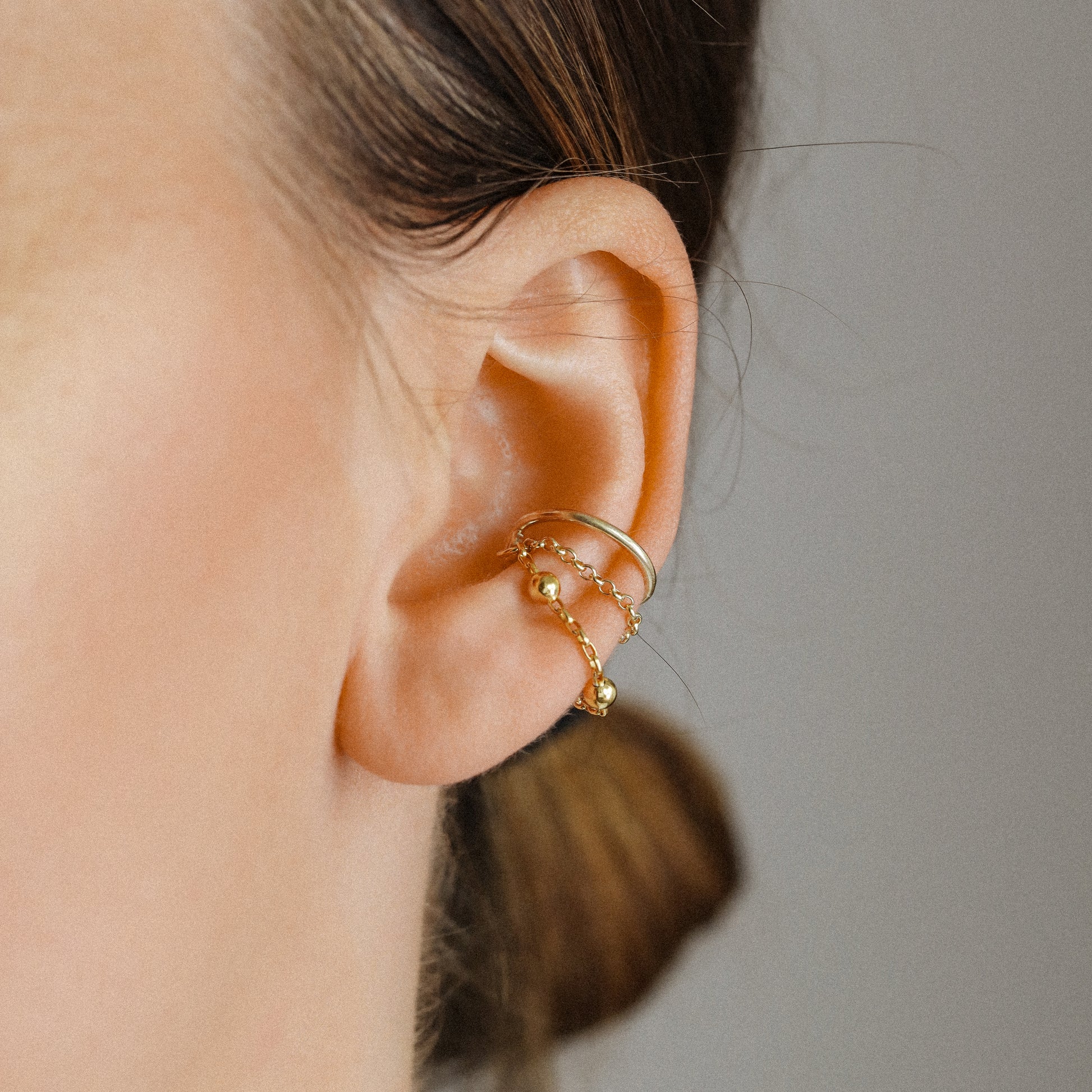 Gold beaded chain ear cuff worn on the conch with double draped chain detail