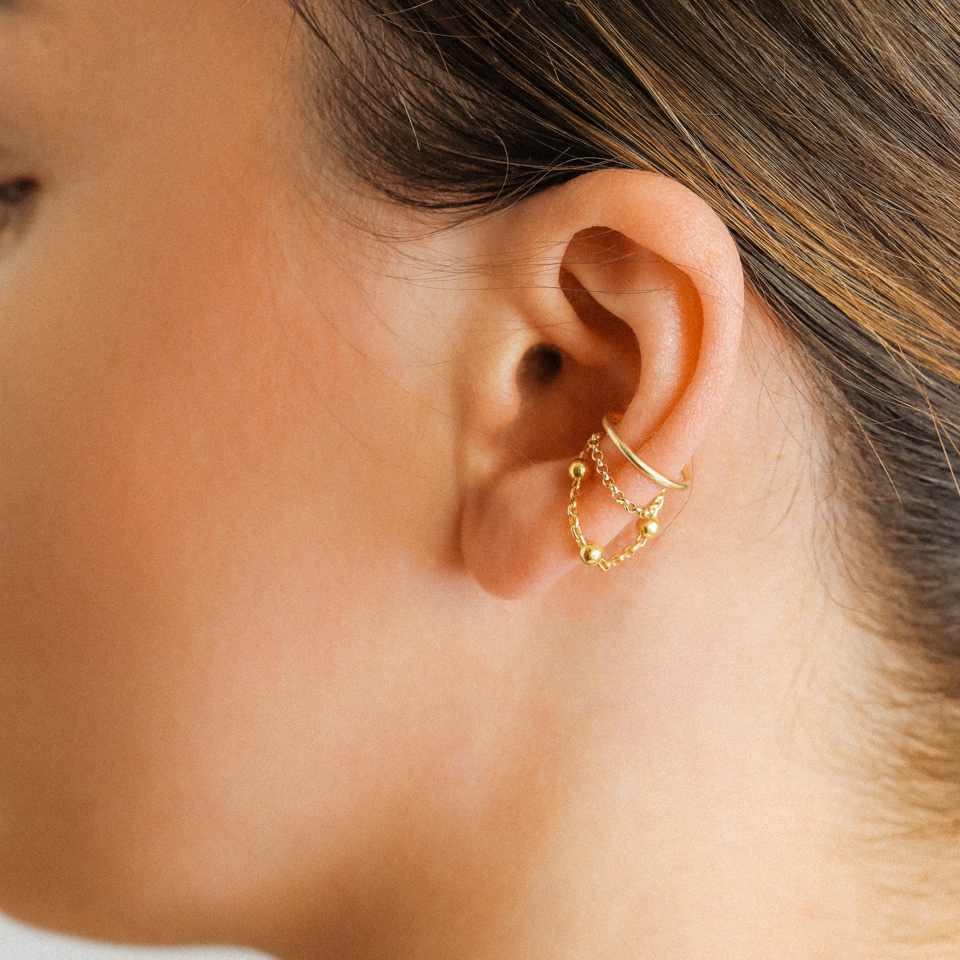 Gold beaded chain ear cuff worn on the conch with double draped chain detail