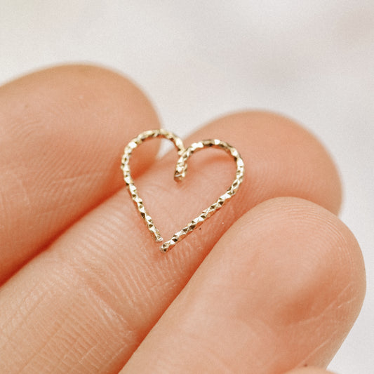 Detail of the gold heart hoop's "bend-and-twist" opening mechanism for easy piercing insertion.