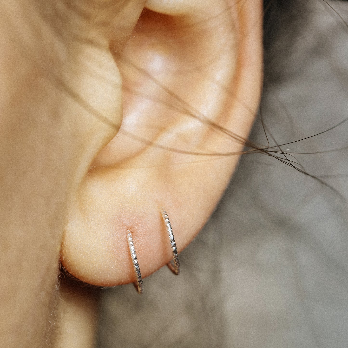 Minimal silver double hoop earrings on ear, tiny spiral earrings, sterling silver illusion double piercing jewelry