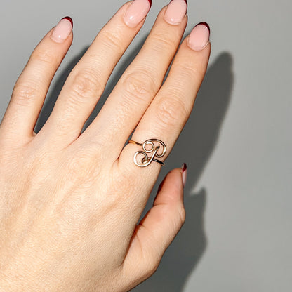 Handmade dainty gold wire ring featuring an uppercase cursive letter P, styled on a hand with red french tip nails.